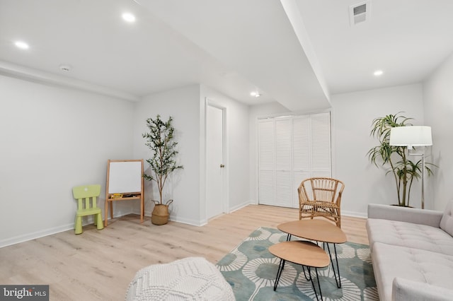 living area with recessed lighting, light wood-style flooring, and baseboards