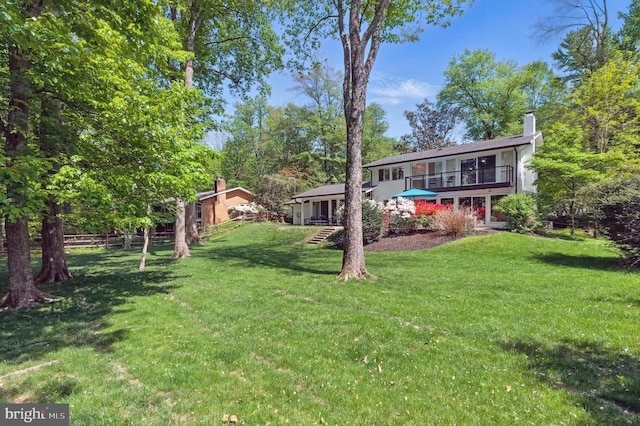 view of yard with fence and a balcony