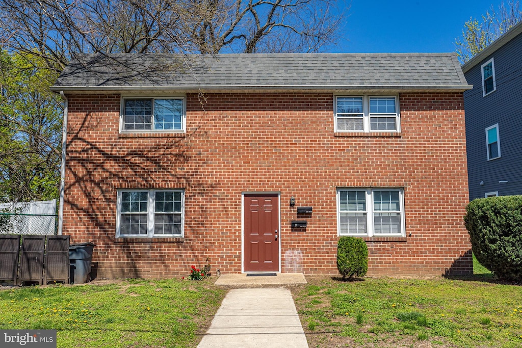 336 Iroquois St, Essington, PA 19029 - colonial-style house with brick siding, a front yard, and roof with shingles