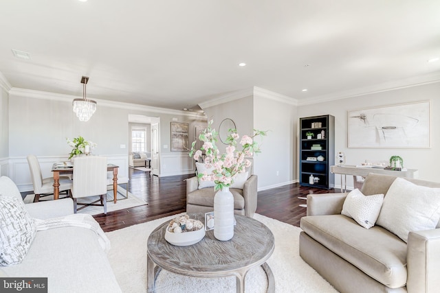 living room with a wainscoted wall, an inviting chandelier, ornamental molding, recessed lighting, and dark wood-type flooring