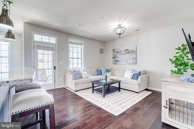 living area featuring dark wood-style flooring, baseboards, and visible vents