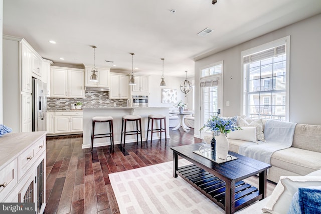 living area featuring recessed lighting, visible vents, and dark wood-style floors