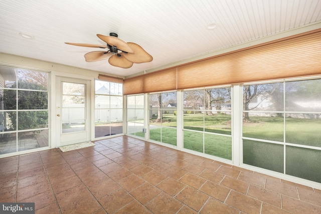unfurnished sunroom featuring ceiling fan
