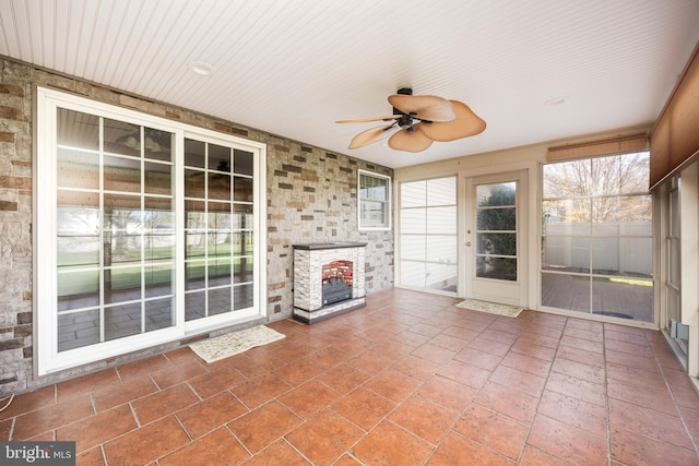 unfurnished sunroom with ceiling fan