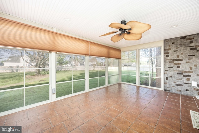 unfurnished sunroom with ceiling fan