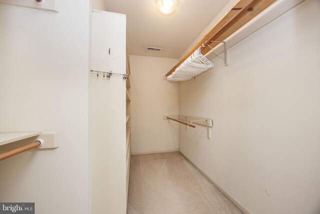 spacious closet featuring light colored carpet and visible vents