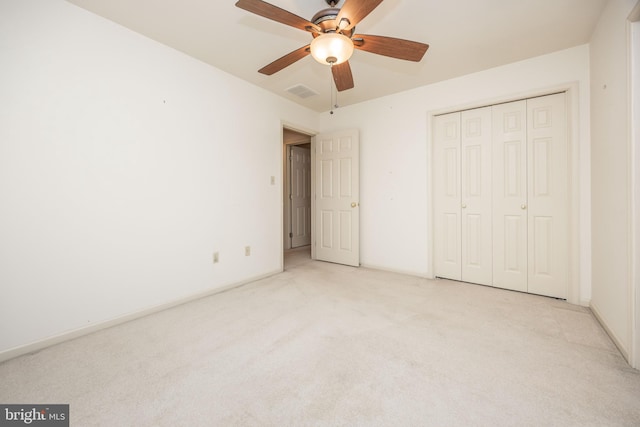 unfurnished bedroom with carpet, visible vents, a closet, baseboards, and ceiling fan