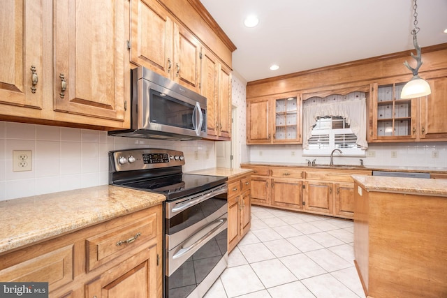 kitchen with a sink, light tile patterned flooring, crown molding, decorative backsplash, and appliances with stainless steel finishes