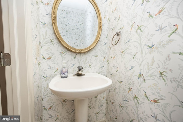 bathroom featuring wallpapered walls and a sink