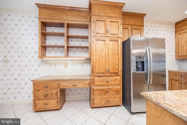 kitchen with wallpapered walls, built in study area, stainless steel fridge with ice dispenser, open shelves, and light tile patterned floors