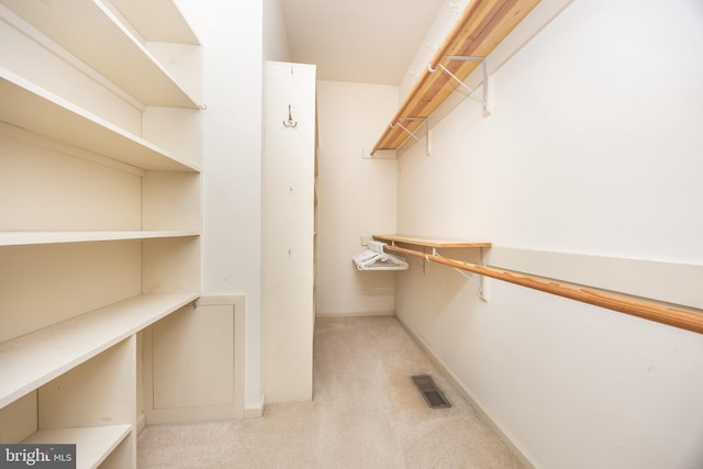 spacious closet featuring visible vents and light colored carpet