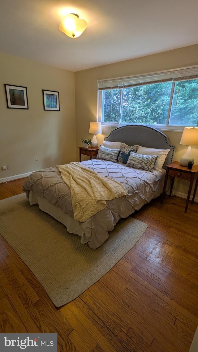 bedroom featuring wood-type flooring and baseboards
