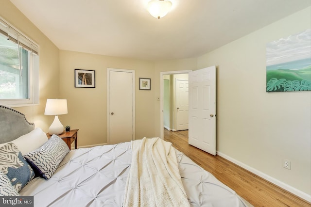 bedroom featuring baseboards and wood finished floors