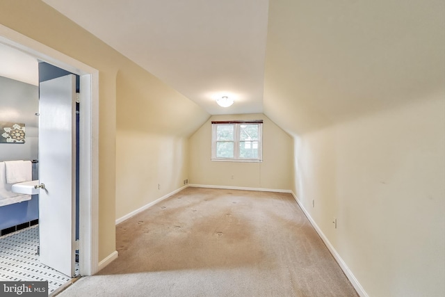 additional living space with carpet flooring, baseboards, and lofted ceiling