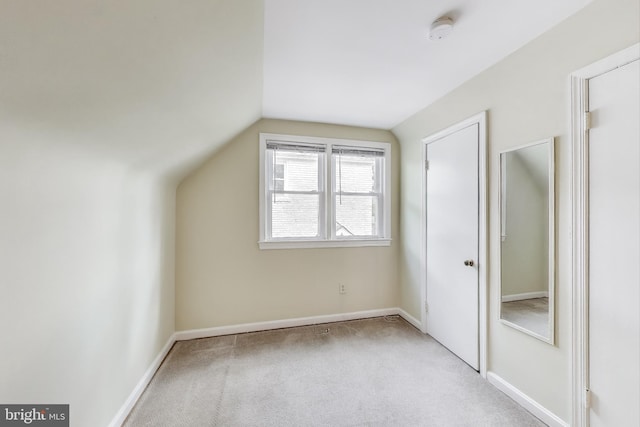 additional living space with baseboards, carpet, and lofted ceiling