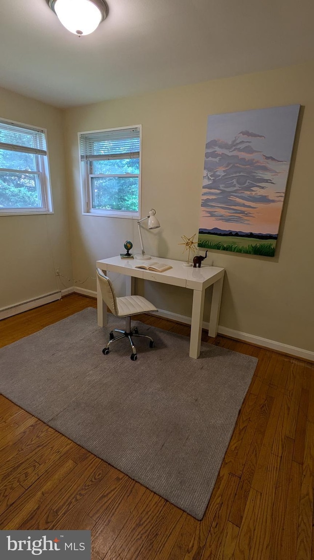 home office featuring baseboards, a baseboard radiator, and wood finished floors