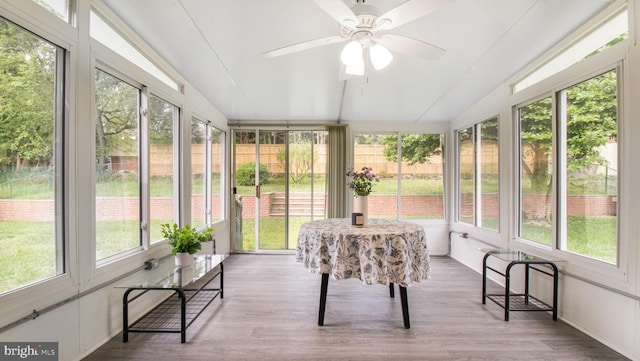 sunroom with a wealth of natural light, lofted ceiling, and wood finished floors
