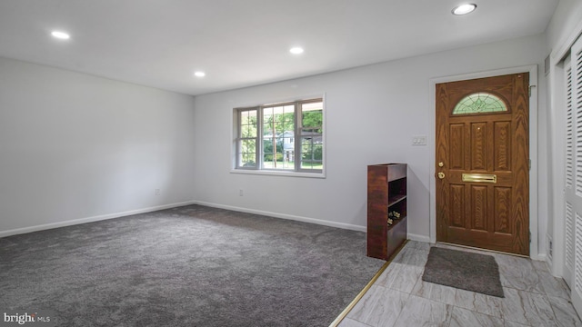 carpeted foyer featuring recessed lighting and baseboards