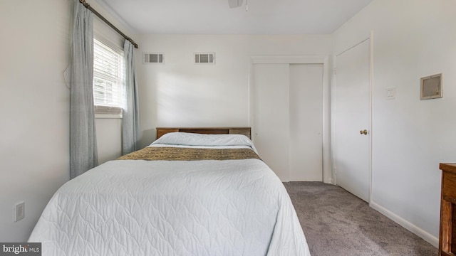 carpeted bedroom with visible vents and a closet
