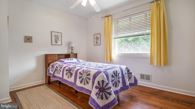bedroom featuring ceiling fan, baseboards, visible vents, and wood finished floors