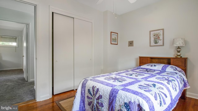 bedroom featuring a closet, baseboards, ceiling fan, and wood finished floors