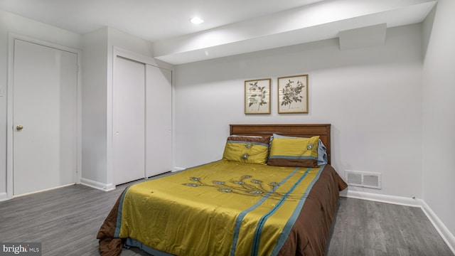 bedroom featuring visible vents, a closet, wood finished floors, baseboards, and recessed lighting