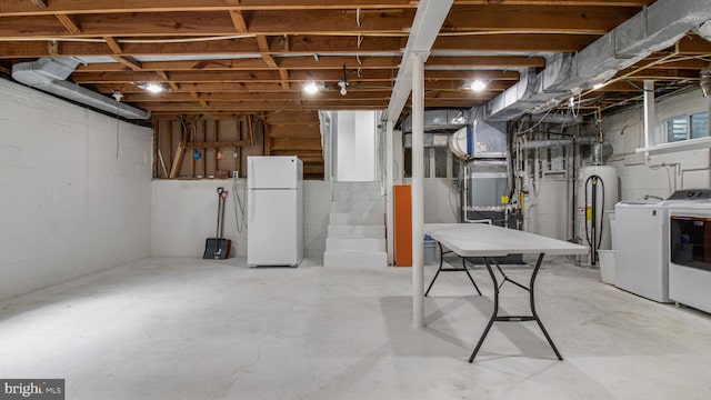unfinished below grade area featuring freestanding refrigerator, washer and clothes dryer, and water heater