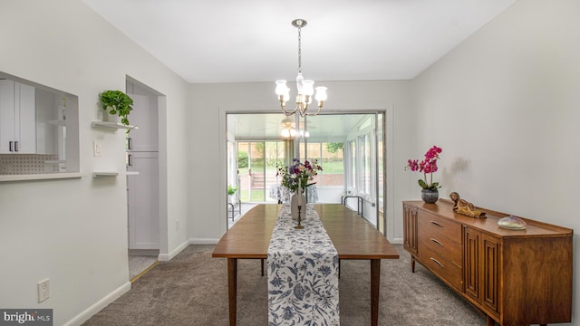 carpeted dining area with baseboards and a chandelier