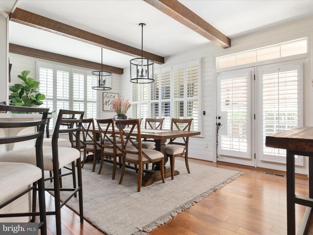 dining room featuring beamed ceiling, visible vents, and light wood-style floors