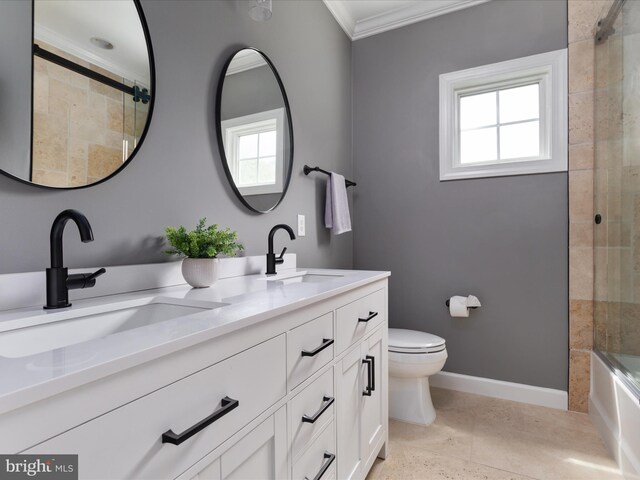 bathroom featuring crown molding, a sink, a healthy amount of sunlight, and toilet