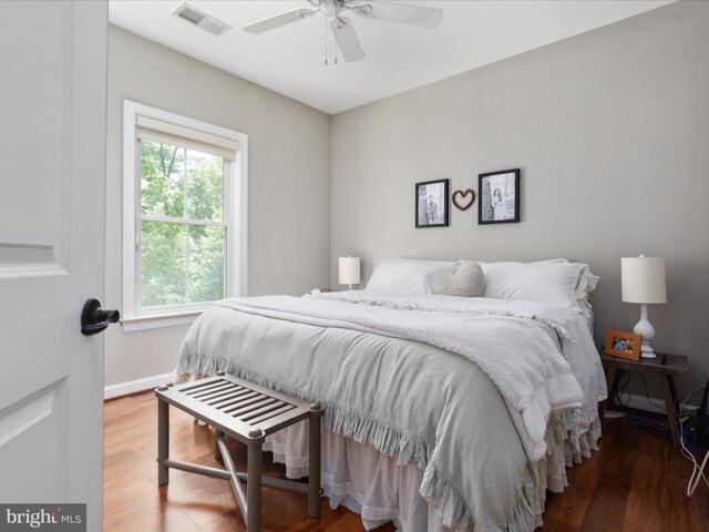 bedroom with visible vents, baseboards, ceiling fan, and wood finished floors
