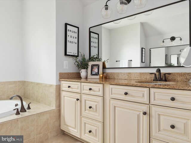 full bath featuring vanity and tiled tub