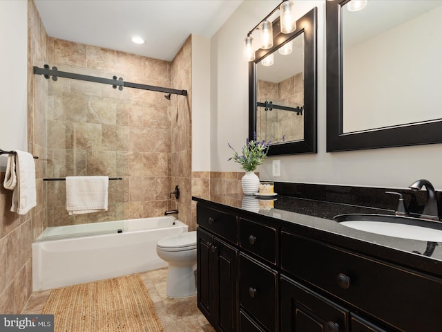 bathroom featuring vanity, bathtub / shower combination, toilet, and tile walls