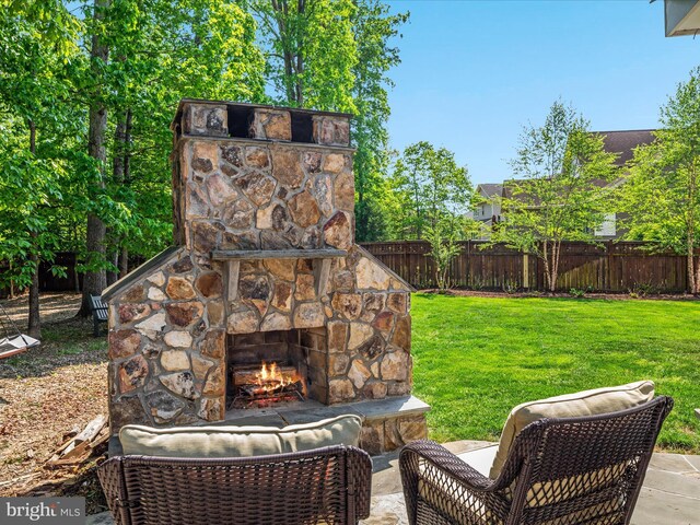 view of patio featuring fence and an outdoor stone fireplace