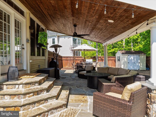 view of patio / terrace with outdoor dining area, a storage shed, an outdoor structure, a fenced backyard, and outdoor lounge area