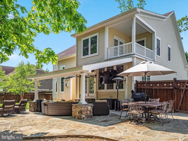 back of house with a patio, outdoor lounge area, fence, and a balcony