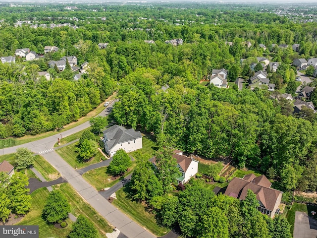 drone / aerial view with a wooded view and a residential view