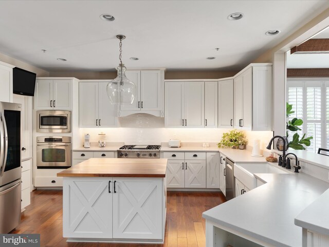 kitchen featuring dark wood-style flooring, white cabinets, a sink, wood counters, and appliances with stainless steel finishes