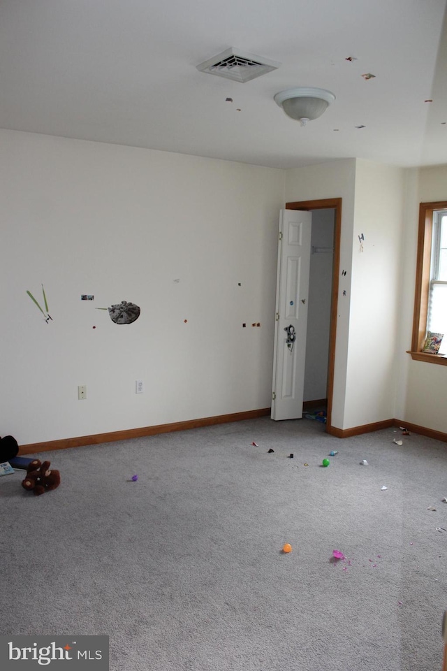 carpeted spare room with baseboards and visible vents