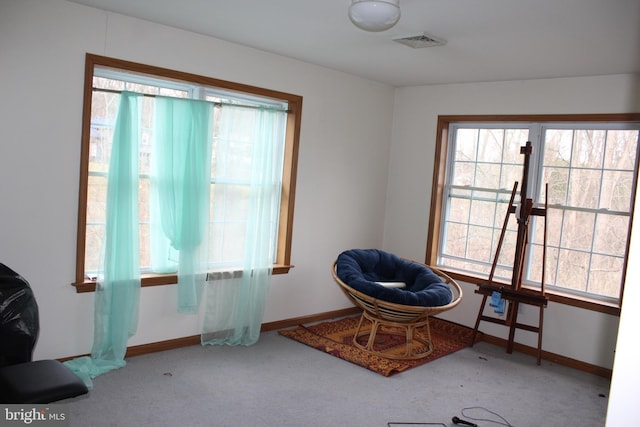 living area with carpet floors, visible vents, and baseboards