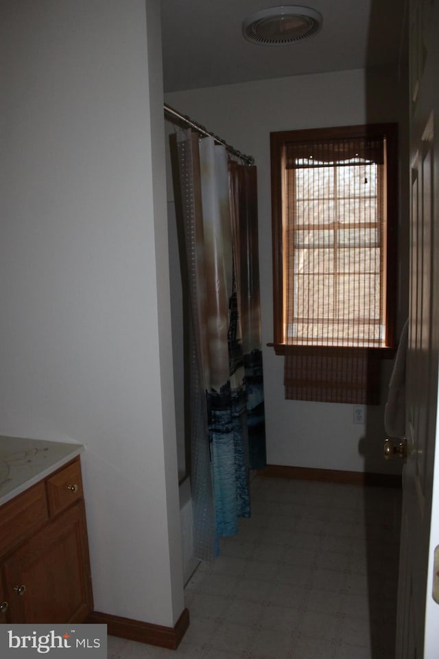 bathroom featuring tile patterned floors, baseboards, visible vents, and vanity