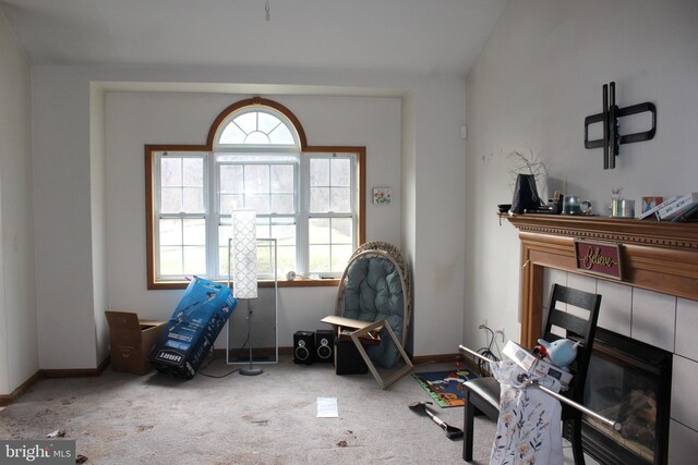 sitting room with a fireplace, carpet floors, lofted ceiling, and baseboards