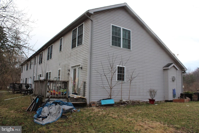 view of home's exterior with a lawn and a deck