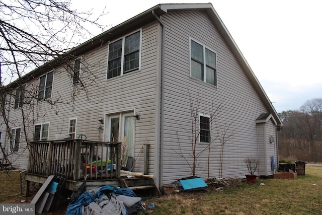 rear view of property featuring a wooden deck and a yard