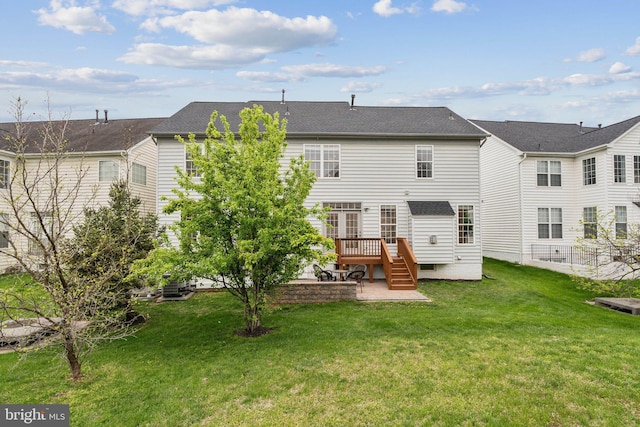 back of property with a wooden deck, a lawn, and a patio