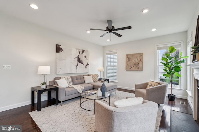 living area featuring ceiling fan, baseboards, a healthy amount of sunlight, and wood finished floors