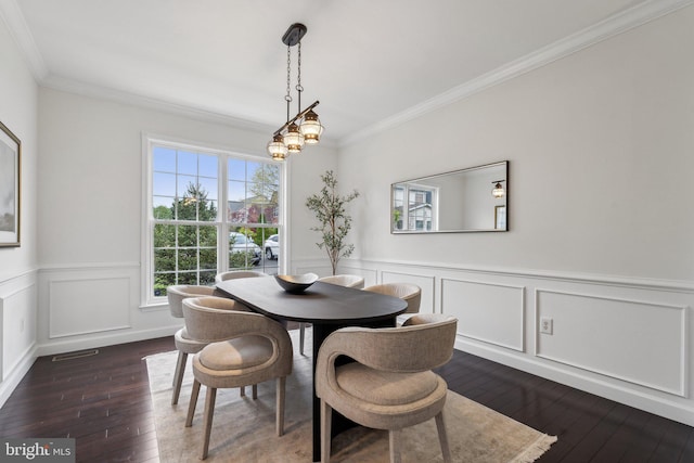 dining space featuring wood-type flooring, a decorative wall, a wainscoted wall, and ornamental molding