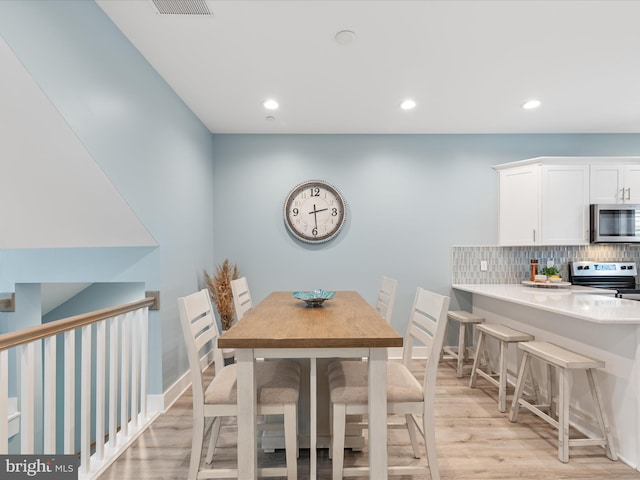 dining area with baseboards, recessed lighting, and light wood-type flooring
