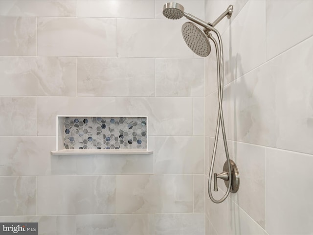 interior details featuring a tile shower