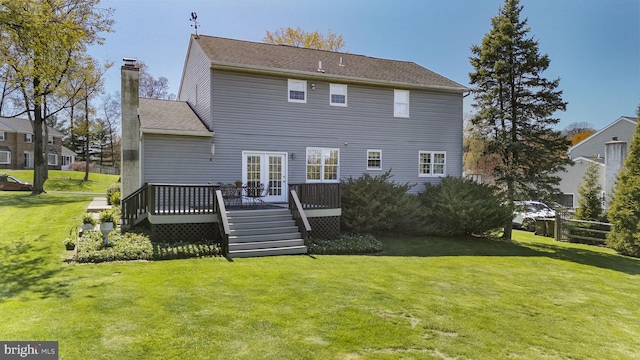rear view of house featuring a chimney, a wooden deck, and a yard